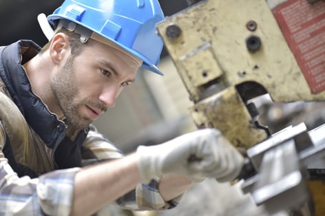 Industrial worker working on machine in factory.jpeg